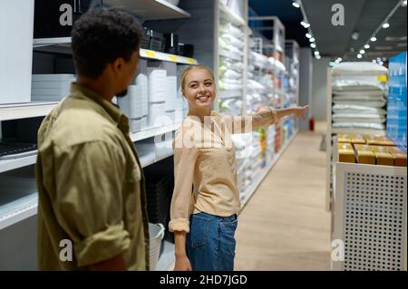 Glückliches Paar, das Haushaltswaren im Laden kauft Stockfoto