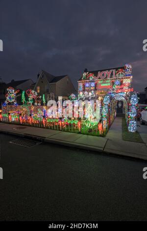 Ein Haus in Bayside, Queens, mit verzierten Weihnachtsdekorationen auf ihrem Gebäude und dem Rasen vor dem Haus. Stockfoto