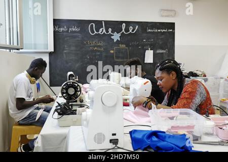 Politische Flüchtlinge arbeiten an einer Schneiderei der gemeinnützigen Vereinigung Linea Adele in Mailand. Stockfoto