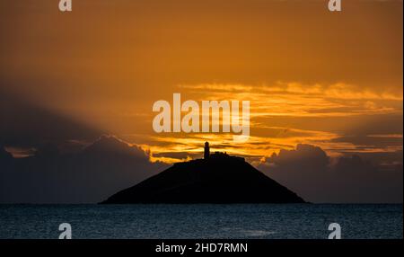 Ballycotton, Cork, Irland. 04th. Januar 2022. Sonnenschein bricht bei Sonnenaufgang hinter Ballycotton Island in Co. Cork, Irland, durch Wolken. - Bild David Creedon Stockfoto