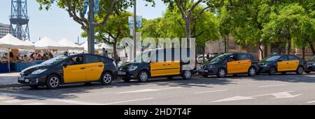 Barcelona, Spanien - 08 2018. Juni: Eine Reihe von schwarzen und gelben Taxis, die am Strand geparkt sind. Stockfoto