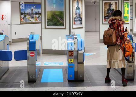 Passagier, der am Bahnhof Tokio durch die Fahrkartenschalter für Shinkansen-Züge fährt. Selektiver Fokus – Fokus auf Ticketschalter. Stockfoto