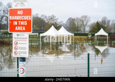 Schild „No Barbecues in this area“ mit Blick auf den überfluteten öffentlichen Park in Stourport-on-Severn, Worcestershire, Großbritannien, aufgrund der Flutkatastrophe des Flusses Severn. Stockfoto