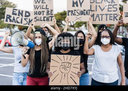 Menschen aus verschiedenen Kulturen und Rassen protestieren während des Coronavirus-Ausbruchs auf der Straße für Gleichberechtigung – Fokus auf das Gesicht älterer Frauen Stockfoto