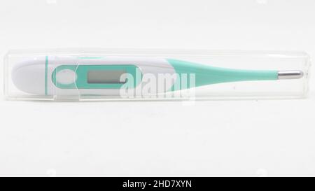 Ein brandneues Digitalthermometer, das in einem Glasgehäuse mit weißem Hintergrund aufbewahrt wird Stockfoto