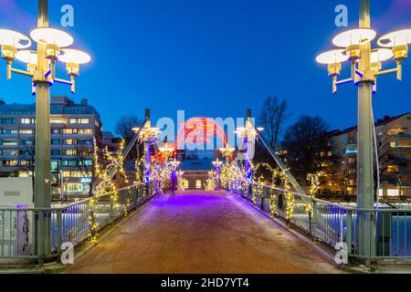 Nachtansicht der Teatterisilta Brücke mit Blick auf den Aura Fluss, beleuchtet von Weihnachtsdekorationen. Stockfoto