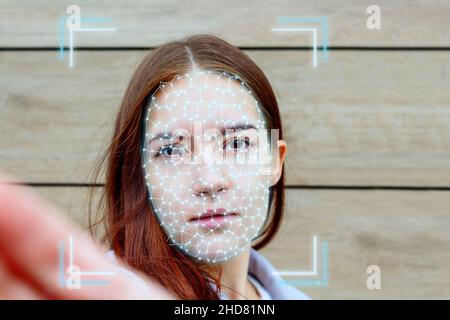 Junge Frau Gesicht während ai-Authentifizierung Biometrie. Stockfoto