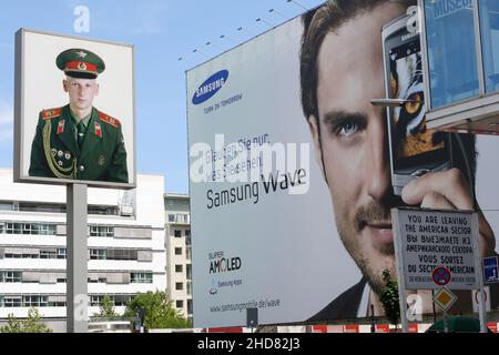 Blick auf das Schild am Checkpoint Charlie im Sommer. Ehemaliger Grenzübergang zwischen West- und Ost-Berlin während des Kalten Krieges. Hintergrund des klaren blauen Himmels Stockfoto