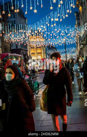 Shopper auf der Oxford Street, einer berühmten Einkaufsstraße mit beleuchteten Weihnachtslichtern, London, England, Großbritannien Stockfoto