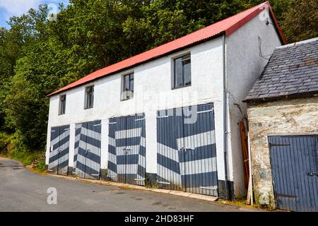 Garagen in Crinan mit Türen, die im blendenden Stil gestrichen sind Stockfoto