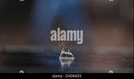 04. Januar 2022, Hessen, Frankfurt/Main: Wasser spritzt in einer Pfütze auf dem Frankfurter Römerberg nach dem Aufprall eines Wassertropfens auf. Das neue Jahr hat mit Dauerregen in der Mainmetropole begonnen. Foto: Arne Dedert/dpa Stockfoto