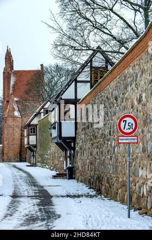 Mittelalterliche Stadtmauer mit Wieck-Häusern (norddeutsche Variante eines Wachhauses) im Winter, Neubrandenburg, Deutschland. Stockfoto