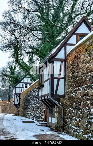 Mittelalterliche Stadtmauer mit Wieck-Häusern (norddeutsche Variante eines Wachhauses) im Winter, Neubrandenburg, Deutschland. Stockfoto