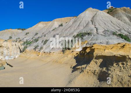 Steile, blaue Tonhänge, mit abfallenden Trümmern, die auf Kalkstein entlang der Küste von Gozo, Malta, Geröll bilden Stockfoto