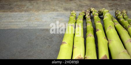 Satz wilder grüner Spargel auf einem grauen Schieferhintergrund in vertikaler Ansicht Stockfoto