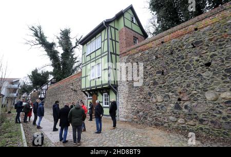 Neubrandenburg, Deutschland. 04th Januar 2022. Das renovierte grüne Wiekhaus Nr. 13 in der historischen Stadtmauer wird als zukünftiger Nutzer offiziell an den Hochschulförderverein übergeben. Es handelt sich um das erste sanierte Gebäude innerhalb eines neuen Wiekhaus-Konzepts, wonach alle 23 Häuser schrittweise saniert und für verschiedene Zwecke zur Verfügung gestellt werden. Quelle: Bernd Wüstneck/dpa-Zentralbild/ZB/dpa/Alamy Live News Stockfoto