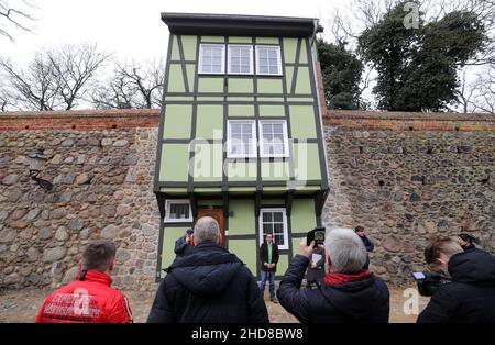 Neubrandenburg, Deutschland. 04th Januar 2022. Das renovierte grüne Wiekhaus Nr. 13 in der historischen Stadtmauer wird als zukünftiger Nutzer offiziell an den Hochschulförderverein übergeben. Es handelt sich um das erste sanierte Gebäude innerhalb eines neuen Wiekhaus-Konzepts, wonach alle 23 Häuser schrittweise saniert und für verschiedene Zwecke zur Verfügung gestellt werden. Quelle: Bernd Wüstneck/dpa-Zentralbild/ZB/dpa/Alamy Live News Stockfoto