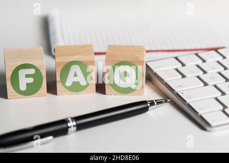 Häufig gestellte Fragen zu Holzblöcken auf dem Schreibtisch mit Computertastatur, häufig gestellte Fragen Konzept Stockfoto