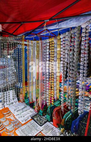 Ausstellung von Metallgürteln, Souvenirs und Schmuck auf dem Nachtmarkt in der Fußgängerzone im Zentrum von Luang Prabang, im Norden von Laos, Südostasien Stockfoto