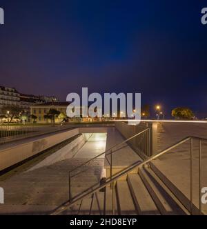 Blick auf den beleuchteten Zugang der Tiefgarage. Campo das Cebolas - Portas do Mar, Lissabon, Portugal. Architekt: carrilho da Graça arquitectos, Stockfoto