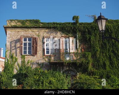 Mittelalterliches Steinhaus in Nafplion Griechenland, mit einzigartigen Blumen an der Wand Stockfoto