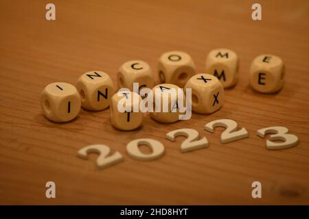 Holzblöcke mit Buchstaben und Holznummern, die die Einkommensteuer 2022-3 angeben Stockfoto