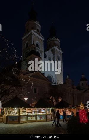 Brixen, Italien (1st. Januar 2022) - der traditionelle Weihnachtsmarkt auf dem Hauptplatz mit der barocken Kathedrale Stockfoto