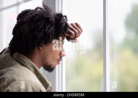 Herbstliche Schwermut. Nahaufnahme Des Nachdenklichen Jungen Schwarzen Guys, Der Aus Dem Fenster Schaut Stockfoto