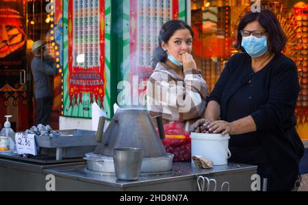 Lisboa, Portugal, Oktober 29,2021: Baixa Eine Mutter und ihre junge Tochter verkauften Kastanien auf der Straße. Stockfoto