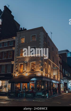 London, Großbritannien - 23. November 2021: Beleuchtetes Äußeres von Coach and Horses, einem traditionellen Eckpub in einem Gebäude aus dem 18th. Jahrhundert in Soho, einem Stadtteil von London Stockfoto