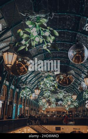 London, Großbritannien - 23. November 2021: Weihnachtsschmuck, Mistel und riesige Festkugeln auf dem Covent Garden Market, einem der beliebtesten Touristenattraktionen Stockfoto