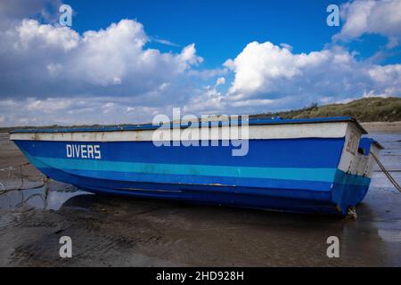 Blaues Fischerboot an einem Strand Stockfoto