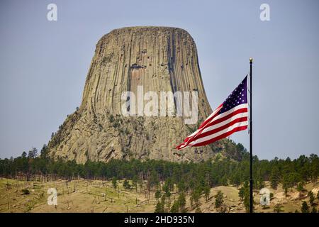 Landschaftlich schöner Blick auf das Devils Tower National Monument und die Flagge der USA Stockfoto