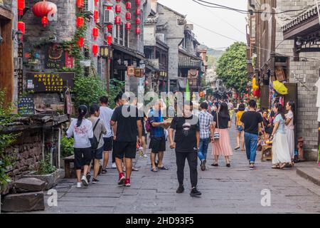 FENGHUANG, CHINA - 13. AUGUST 2018: Überfüllte Kopfsteinpflasterstraße in der Altstadt von Fenghuang, Provinz Hunan, China Stockfoto