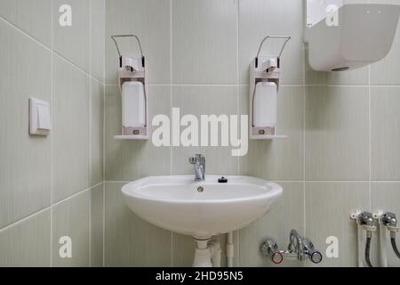 Ellenbogen Seife und antiseptischen Spender oder Desinfektionsmittel Wand zur Händedesinfektion und Wasserhahn Waschbecken mit Wasserhahn Bad oder Klinik montiert Stockfoto
