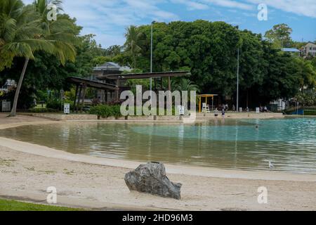 Airlie Beach, Queensland, Australien - 2022. Januar: Menschen stehen, schwimmen und spazieren entlang einer öffentlichen Lagune in einer Touristengemeinde Stockfoto