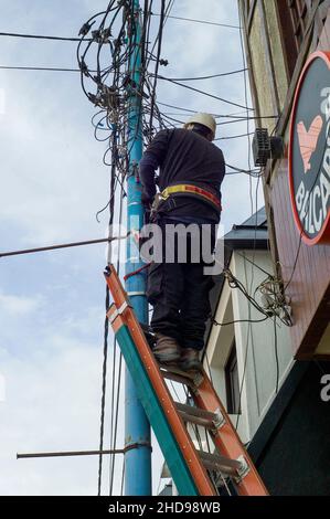 Ingenieur repariert Stromleitungen in der Stadt Ushiaia, Argentinien, Stockfoto