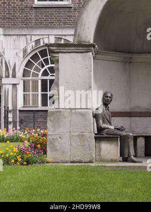 Stuart Williamsons Bronzestatue des Dichters John Keats, der in einer alten Nische auf der London Bridge im Guy's Hospital, Great Maze Pond, London, SE1, Großbritannien, sitzt Stockfoto