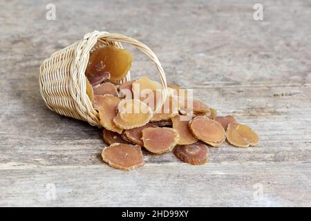 Chinesische Kräutermedizin Koreanischer roter Ginseng (Radix Ginseng rubra) aus einem Korb auf grünem Holzhintergrund Stockfoto