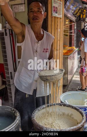 CHONGQING, CHINA - 17. AUGUST 2018: Nudelhersteller in der antiken Stadt Ciqikou, China Stockfoto