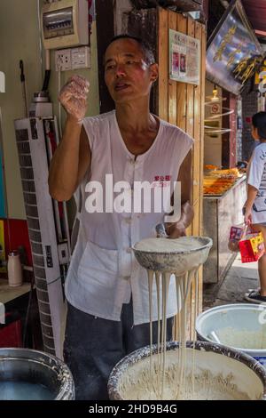 CHONGQING, CHINA - 17. AUGUST 2018: Nudelhersteller in der antiken Stadt Ciqikou, China Stockfoto