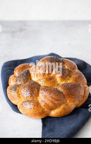 Hausgemachte Rundchallah mit Mohnsamen. Traditionelles, frisch gebackenes jüdisches Gebäck. Draufsicht. Stockfoto