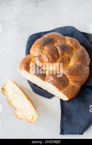 Hausgemachte Rundchallah mit Mohnsamen. Traditionelles, frisch gebackenes jüdisches Gebäck. Draufsicht. Stockfoto