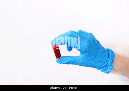 Ärztliches Hand haltende Reagenzglas mit Blutprobe für die Prüfung. Bluttestkonzept. Röhrchen mit Blut für covid-19 Analyse. Stockfoto
