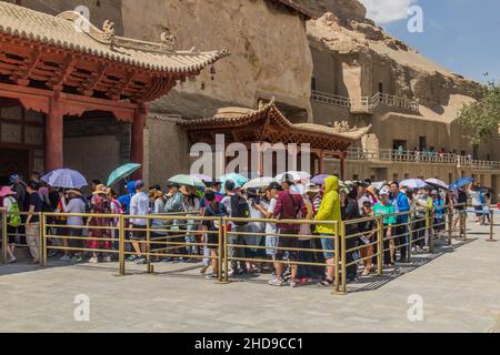 DUNHUANG, CHINA - 20. AUGUST 2018: Schlange am neun-stöckigen Big Buddha-Gebäude in den Mogao-Grotten in der Nähe von Dunhuang, Provinz Gansu, China Stockfoto