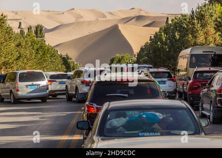 DUNHUANG, CHINA - 20. AUGUST 2018: Verkehr auf einer Straße zur Singing Sands Dune in der Nähe von Dunhuang, Provinz Gansu, China Stockfoto