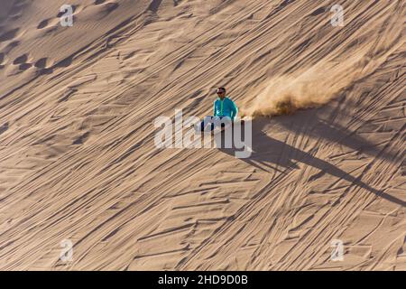 DUNHUANG, CHINA - 21. AUGUST 2018: Sandrodeln auf der Singing Sands Dune in der Nähe von Dunhuang, Provinz Gansu, China Stockfoto