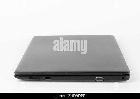 Moderner, neuer, schwarzer Bürolaptop auf weißem Hintergrund, Seitenansicht. USB 2,0-Anschluss, vga-Anschluss. Stockfoto