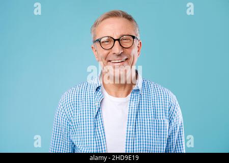 Porträt eines lächelnden, reifen Mannes in einer Brille, der im Studio posiert Stockfoto