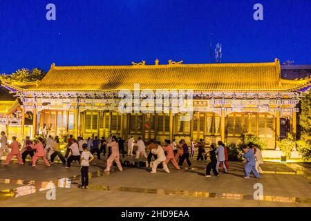 ZHANGYE, CHINA - 22. AUGUST 2018: Abendansicht von Menschen, die in Zhangye, Provinz Gansu, China Tai Chi praktizieren Stockfoto